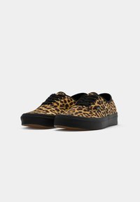 Leopardprint canvas sneakers met zwarte accenten en een rubberen zool, voorzien van ronde veters en een laag profiel ontwerp.