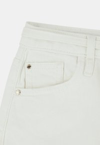 Jeans di denim bianchi con tasca frontale e bottone in argento, vita cucita e tessuto leggermente texturizzato.