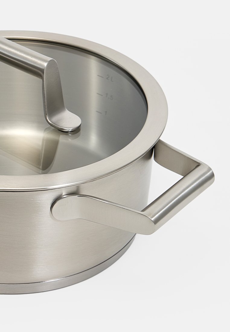Stalowy garnek nierdzewny z szklaną pokrywką i oznaczeniami miar. Posiada nowoczesny design oraz dwa ergonomiczne uchwyty.