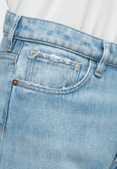 Ανοιχτό μπλε τζιν με σκισμένο σημείο στην πίσω τσέπη, ορατές ραφές και σχεδιασμό κανονικής μέσης.