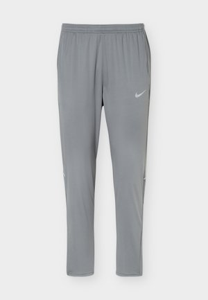 Ανοιχτό γκρι αθλητική παντελόνα Nike με ελαστική μέση και ανακλαστικό λογότυπο στο πάνω αριστερό μηρό, στενή γραμμή και κωνικά μπατζάκια.