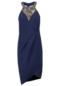 Námořnická modrá bezramínková šaty s asymetrickou zavinovací sukní a metalickým vzorem na výstřihu a ramínkách.