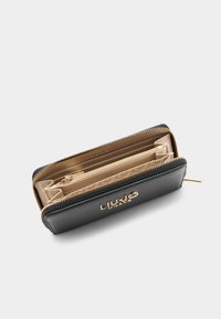 Portafoglio in pelle nera con dettagli in oro, chiusura con cerniera e molteplici scomparti per carte e contanti. Interno con fodera color oro chiaro.