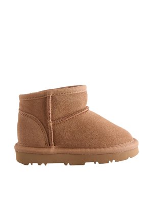 Tanfarbene Wildleder-Stiefelette mit abgerundeter Spitze, niedrigem Schaft, Gummisohle und Ziernähten entlang der Nähte.