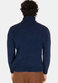 Maglione blu navy con colletto alto e polsi e orlo a costine, caratterizzato da un tessuto a maglia testurizzato e morbido. Nessun logo o motivo visibile.