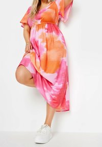 Barevné midi šaty s batikovaným vzorem v odstínech růžové a oranžové, vyrobené z měkkého materiálu s krátkými volánovými rukávy a nařaseným pasem.