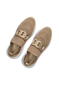 Beige sneakers met een mesh bovenwerk, voorzien van een gouden kettingaccent over de wreef, en een witte rubberen zool. Textile textuur is zichtbaar.