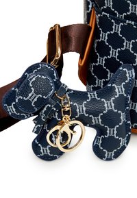 Marinblå mönstrad lädernyckelring formad som en hund med detaljer i guld och ett brunt tygband. Har en texturerad ytfinish.