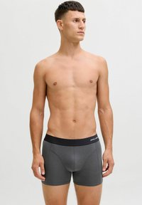 Grau Boxershorts mit einem schwarzen elastischen Bund, der mit Logo-Text versehen ist. Glatte Textur, enganliegendes Design und mittellange Beinlängen.