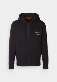 Felpa nera con zip, dotata di cordini, caratterizzata dal logo "BOSS" in blu e da una grafica a onda sonora in beige sulla manica destra.