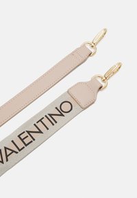 Valentino siksna: viena puse ir bejžā āda, otra puse ir gaiši pelēks audums ar spēcīgu melnu logotipu. Zelta aparatūra pie katras galu.