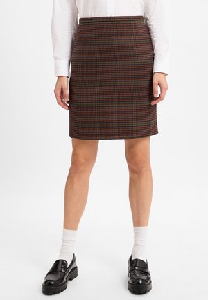 Karierter Rock in Braun-, Rot- und Grüntönen. Maßgeschneiderte Passform mit gerader Silhouette. Tragen mit schwarzen Slippern und weißen Socken.