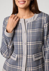 Geruite blazer in navy en beige, met een grijze kraag en zakken, voorzien van knoopsluitingen en een gestructureerde stof.