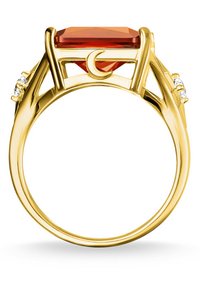 Bague en or ornée d'une grande pierre précieuse rectangulaire orange avec un design en croissant de lune, flanquée de petites pierres claires de chaque côté.