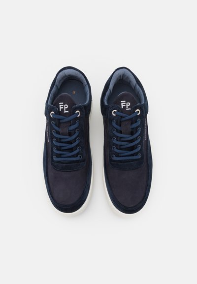 Mørkeblå semskede sneakers med hvit gummisåle. Har runde lisser, polstret krage og en logo på tungen. Interiøret er lyseblå.