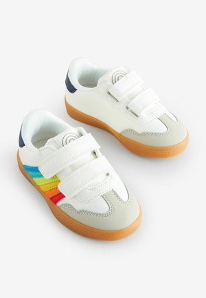 Sneakers bianchi con due cinturini in Velcro, caratterizzati da strisce arcobaleno (blu, verde, arancione) e una suola in gomma. Accenti in blu navy e grigio chiaro.