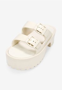 Sandali platform in bianco sporco, con due ampie cinghie regolabili, sottopiede testurizzato e una suola spessa e rigata.