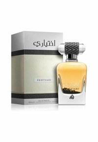 Eau de parfum i en klar glasflaska med ett geometriskt silverlock, försedd med ett svart vävt band. Förpackningslådan har intrikata mönster och arabisk text.
