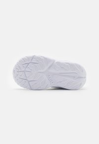 Vit sportskonssula med texturerade greppmönster, med Nike-logotypen och en slät, böjd kant. Gummimaterial för hållbarhet.