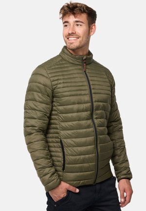 Maslinasto zelena puffer jakna s visokim ovratnikom, horizontalnim šavovima i zatvaranjem na patentni zatvarač, s crnim akcentima i bočnim džepovima. Lagani materijal.