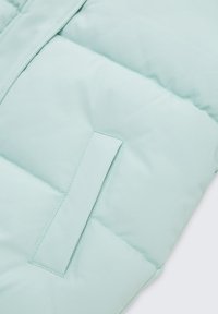 Licht mintgroene puffer vest met een gladde textuur, voorzien van horizontaal gequilte secties en een rechthoekige zak aan de voorkant.