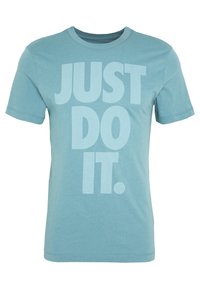 Světle modré bavlněné tričko s velkým, výrazným potiskem "JUST DO IT." v mírně tmavším odstínu. Kulatý výstřih a krátké rukávy.