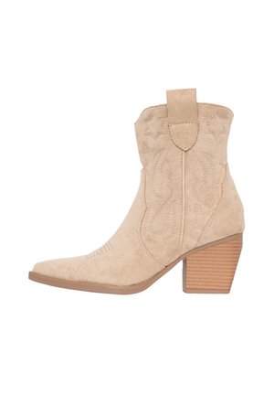Beige suède cowboylaarzen met een pointed toe, decoratieve stiksel en een gestapelde hak. Heeft een trekband aan de achterkant.
