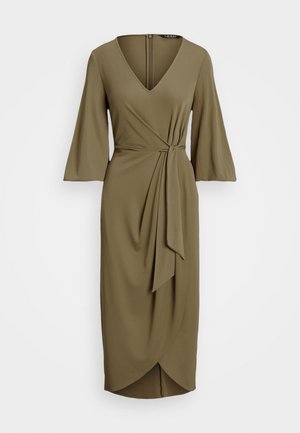 Oliwkowa sukienka kopertowa z dekoltem w serek i trzema ćwierć rękawami; posiada detal w postaci wiązania w talii oraz zwiewny kształt.