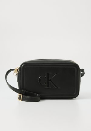 Bolsa crossbody de couro preto com logótipo embossado, forma retangular, fecho com zipper e alça ajustável. Acessórios em tom dourado.