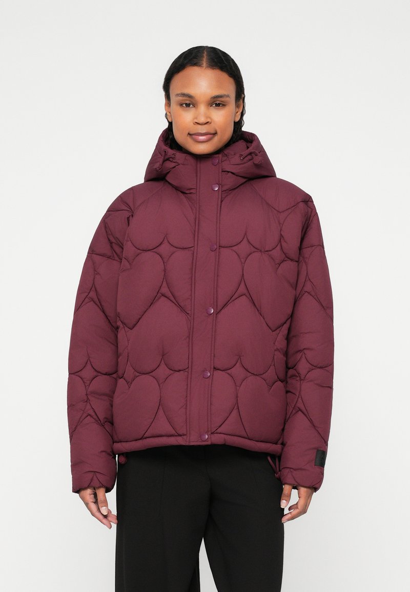 Giacca a vento trapuntata color bordeaux con cuciture a forma di cuore, cappuccio e bottoni a pressione. Presenta una vestibilità comoda ed è realizzata in materiale sintetico.