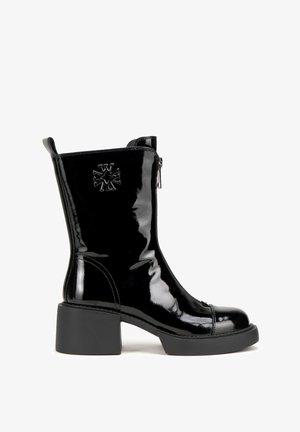 Czarne lakierowane botki za kostkę z masywnym obcasem, zapięcie na zamek, detal wytłoczonego logo oraz gładka, błyszcząca faktura.