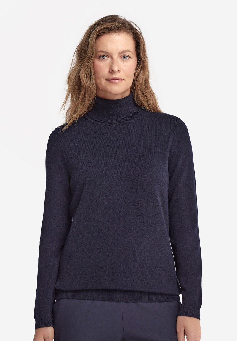 Navyblauer Rollkragenspullover aus weichem Strickstoff. Mit langen Ärmeln und einem lockeren Schnitt. Glatte Textur mit geripptem Kragen und Saum.