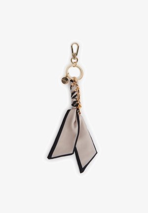 Portachiavi dorato con sciarpa di tessuto beige e nero, dettaglio catena dorata e piccolo charm rotondo.