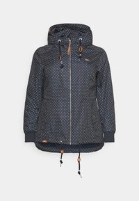 Marinblå vattentät jacka med vita prickar, justerbar huva, främre dragkedja och dragsko i fållen. Har oranga detaljer och fickor.