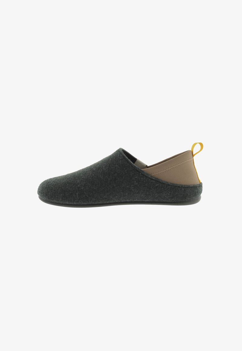 Zapatillas de fieltro en gris oscuro, con un tacón marrón suave, forma redondeada y suela de goma negra. Diseño minimalista con un tirador amarillo.