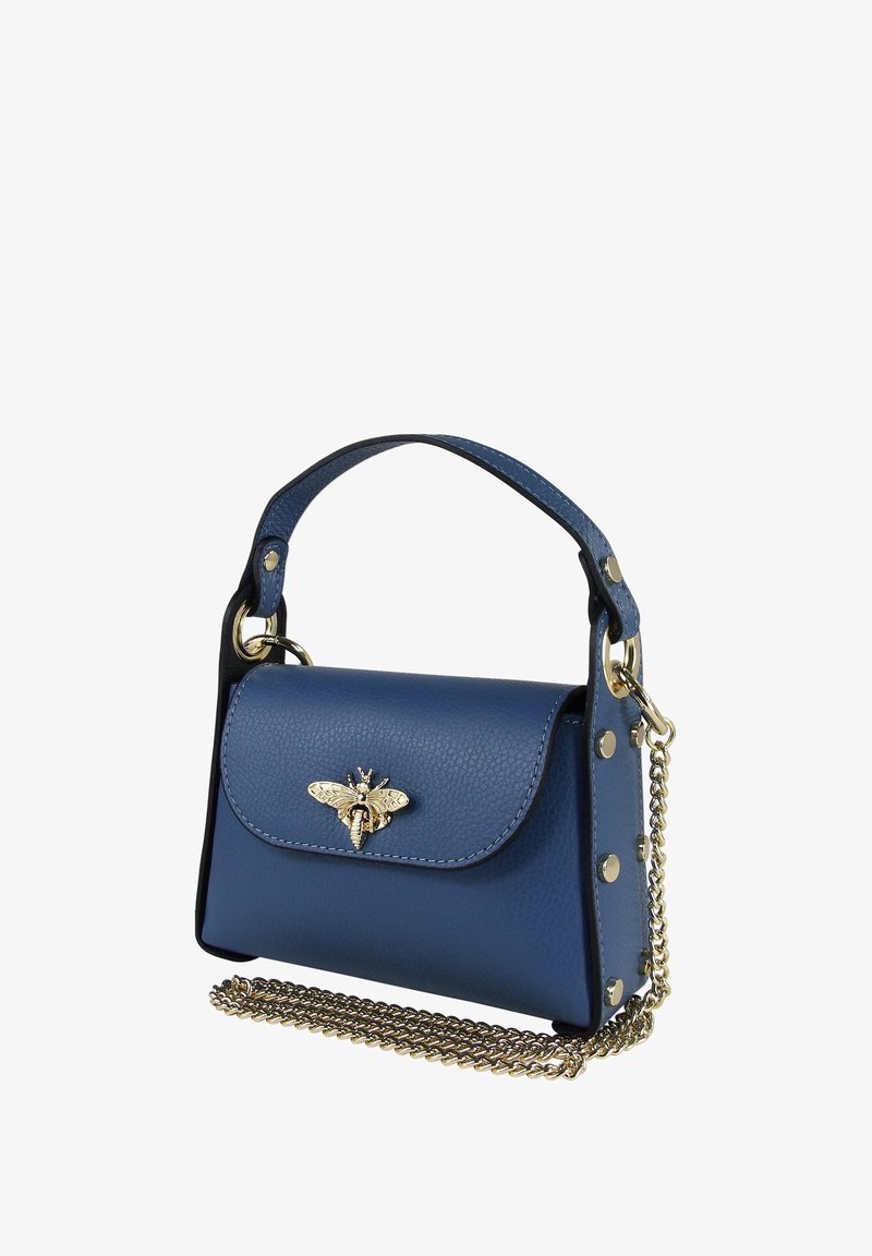Sac à main en cuir bleu avec une fermeture à rabat, orné d'un emblème d'abeille métallique, de clous dorés et d'une bandoulière en chaîne. Forme rectangulaire compacte.
