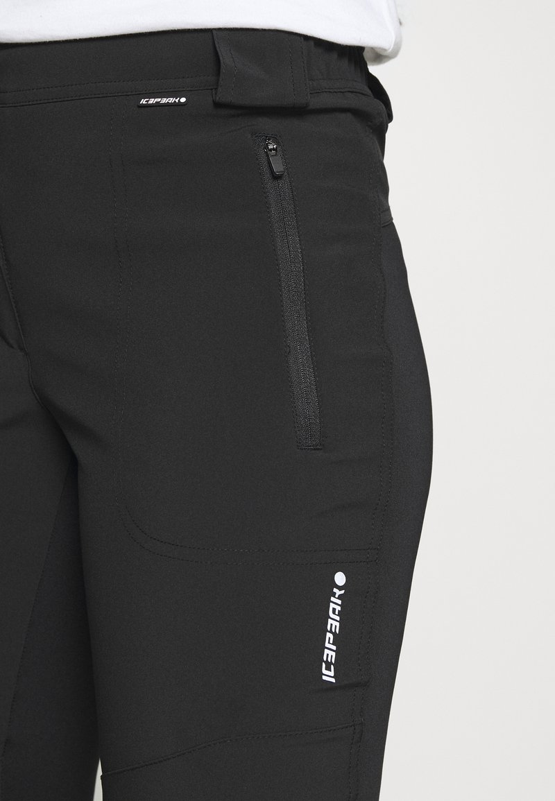 Pantaloni atletici neri realizzati in un tessuto liscio e elasticizzato, con una tasca con zip e un logo bianco sulla coscia. Design a vestibilità slim.