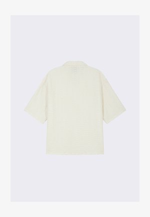 Chemise blanche à manches courtes avec un motif texturé, coupe décontractée et col. Présente des coutures minimales et une finition douce.