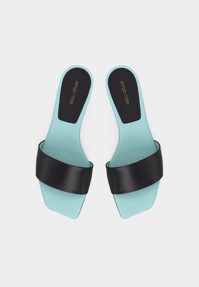 Ζευγάρι τιρκουάζ φλατ σανδάλια με φαρδιές μαύρες λουρίδες και τετράγωνα δάχτυλα, με το λογότυπο "Sergio Rossi" στα μαύρα πέλματα.