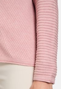 Hellrosa, geripptes Strickpullover mit einem strukturierten Muster und taillierten Ärmeln, einem glatten, weichen Finish und einem dezenten Saumdetail.