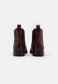 Bottines Chelsea en motif serpent marron avec panneaux latéraux élastiques et languette de tirage. Finition lisse et talon superposé offrant un design structuré.
