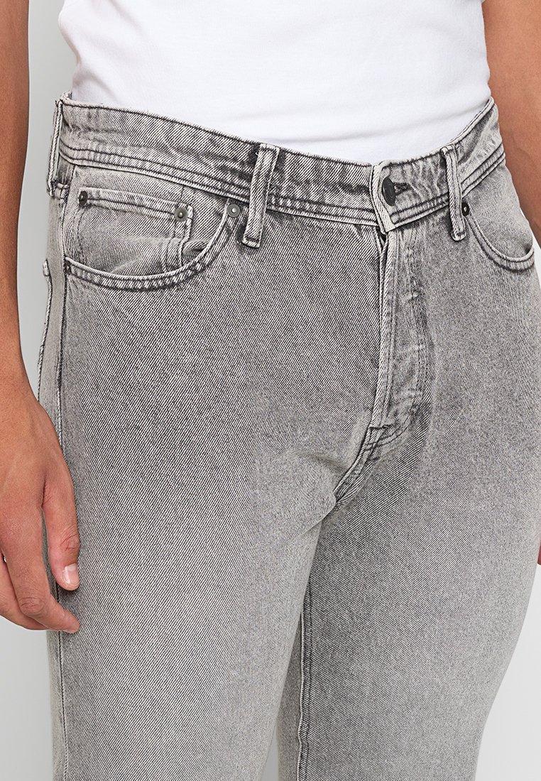 Schwarze Denim-Jeans mit schmaler Passform, ausgestattet mit einem Fünf-Taschen-Design, dezenten Abnutzungserscheinungen und silberfarbenen Metallbeschlägen.