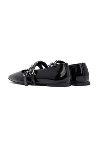Ballerine in vernice nera con punta affusolata, dotate di ornamenti in argento decorativi e due cinturini alla caviglia. Texture liscia, suola piatta.