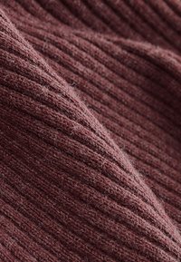 Strikket stof med struktur i dyb burgunderfarve, med et ribbet mønster. Blød, lodden overflade med synlige fibre og subtil glans.