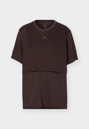 T-shirt superposé Adidas à manches courtes de couleur marron foncé, col rond et logo subtil sur la poitrine, présenté sur fond blanc.