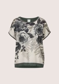 Blouse à manches courtes avec imprimé floral noir et gris et motifs feuillus sur fond blanc, avec un col et un ourlet gris foncé.