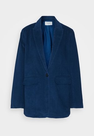 Laivastonsininen corduroy-takki, jossa on viistetyt kaulukset, yksittäinen napitus ja kaksi etutaskua. Värikäs kangas, jossa on pystysuora uritus.