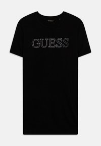 Camiseta de algodón negra con la palabra "GUESS" en strass en el pecho, con un cuello redondo clásico y mangas cortas.