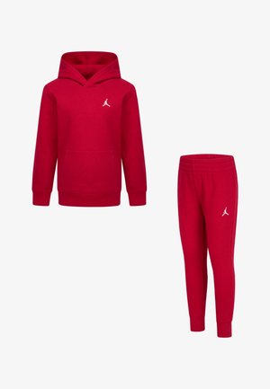 Conjunto de sudadera con capucha roja y pantalones deportivos a juego. Ambos presentan un logo blanco. La tela parece suave, con puños y cinturilla elásticos.