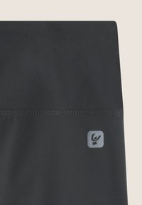 Leggings neri realizzati in un tessuto morbido e elasticizzato. Rifiniti con cuciture a contrasto e un piccolo logo grigio sulla parte inferiore sinistra.